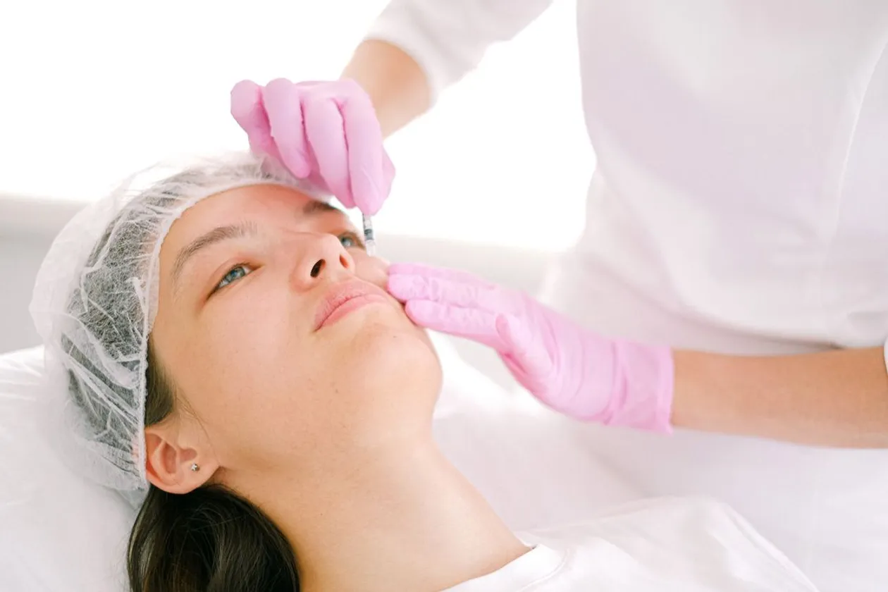 Médica aplicando un tratamiento estético facial